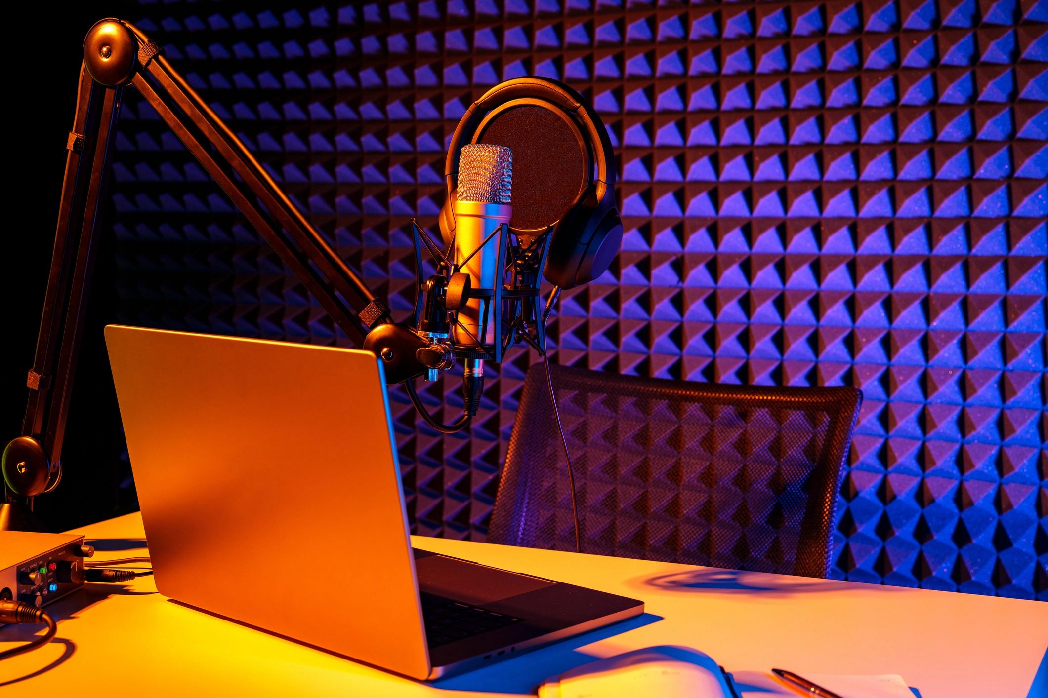 Voice recording desk with microphone and chair in a clean studio